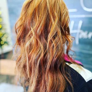 Woman with long red hair and highlights.